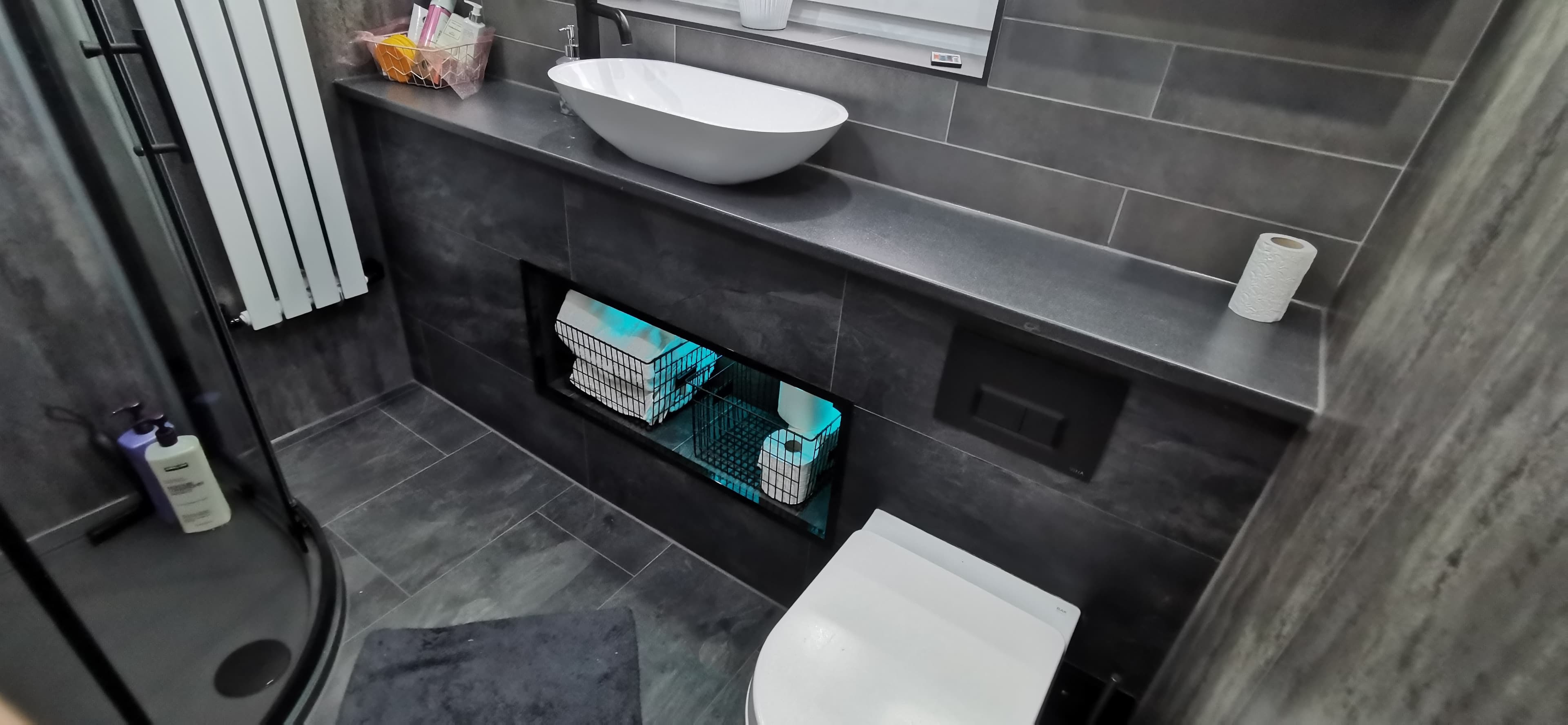 Finished bathroom refit with wall-hung WC, vessel basin and tiled walls