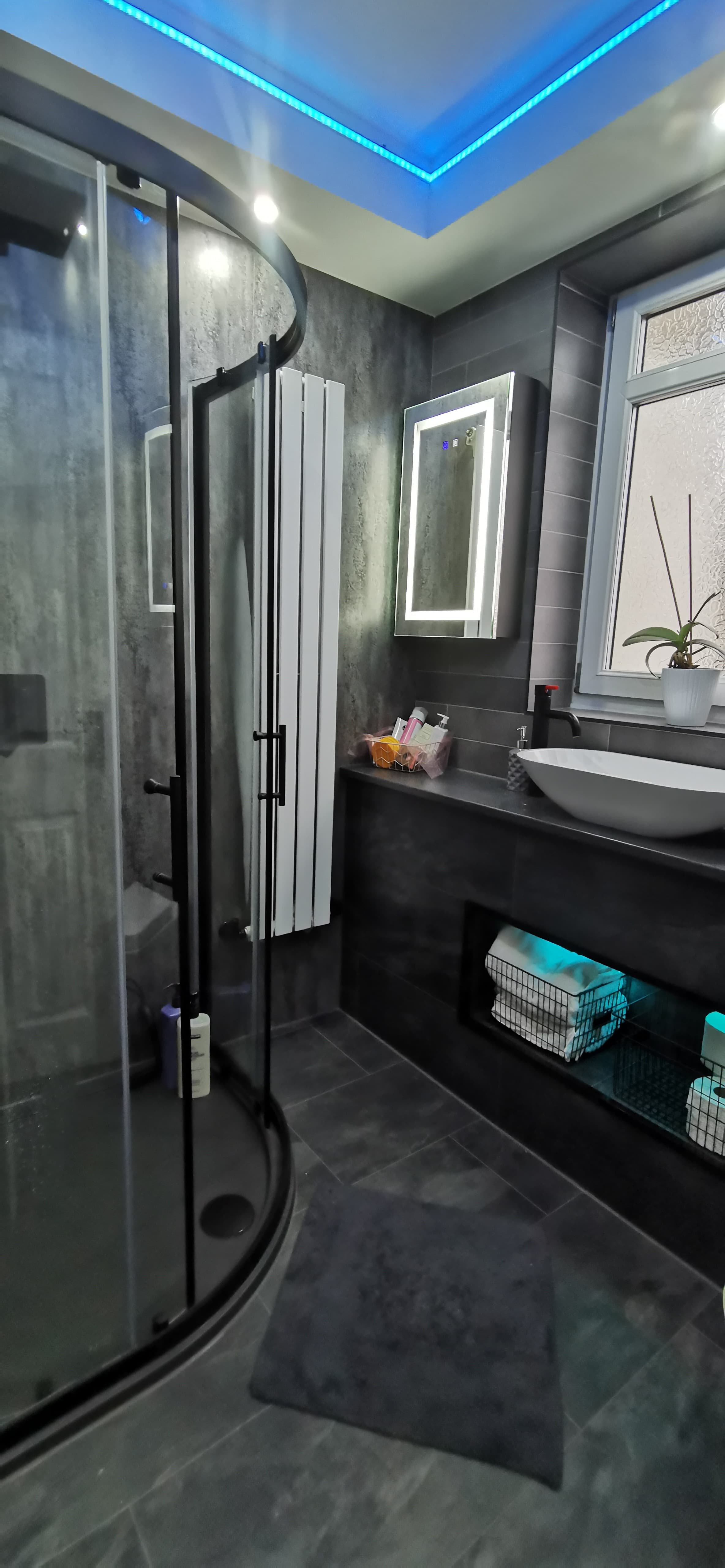 Illuminated storage niche with LED lighting in a tiled bathroom