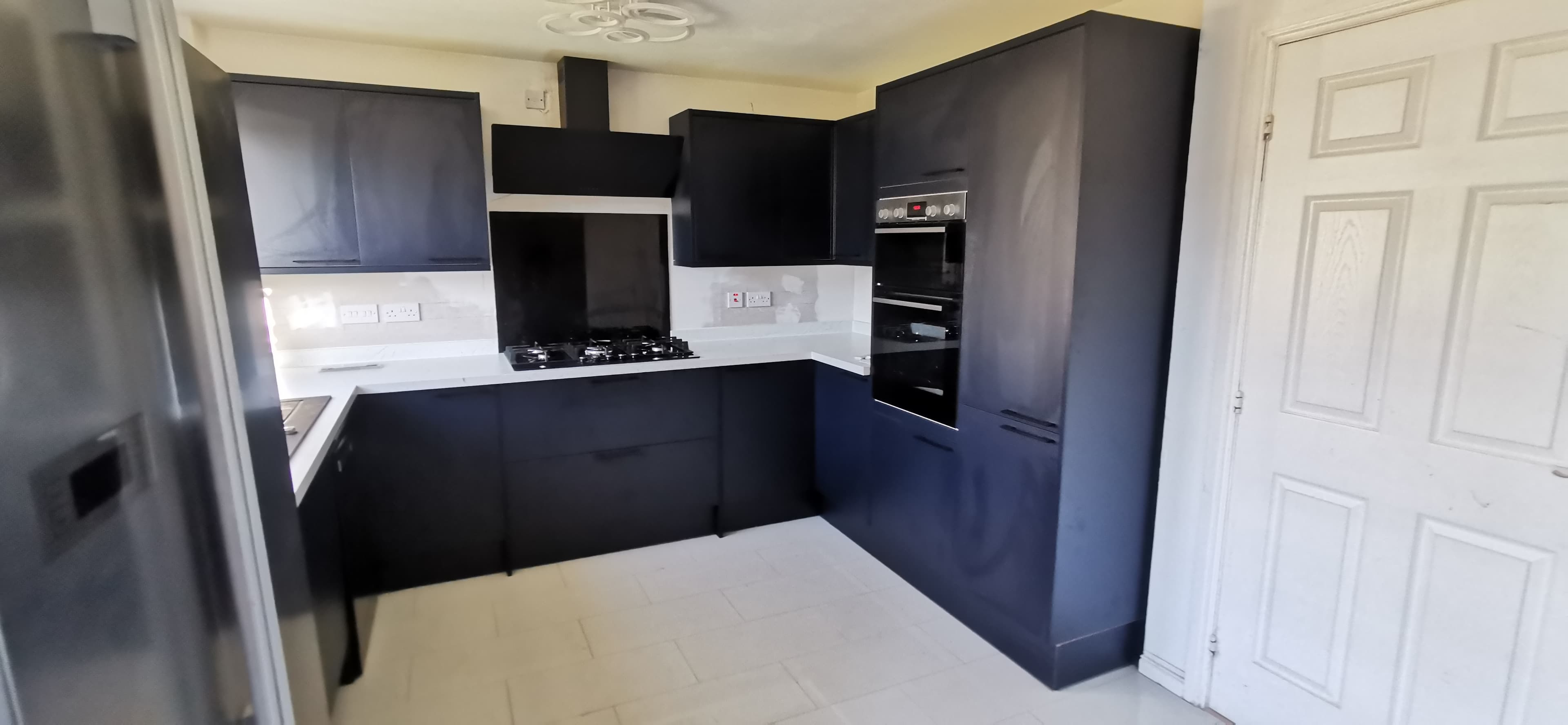 Handleless kitchen cabinetry with quartz worktop and undermount sink