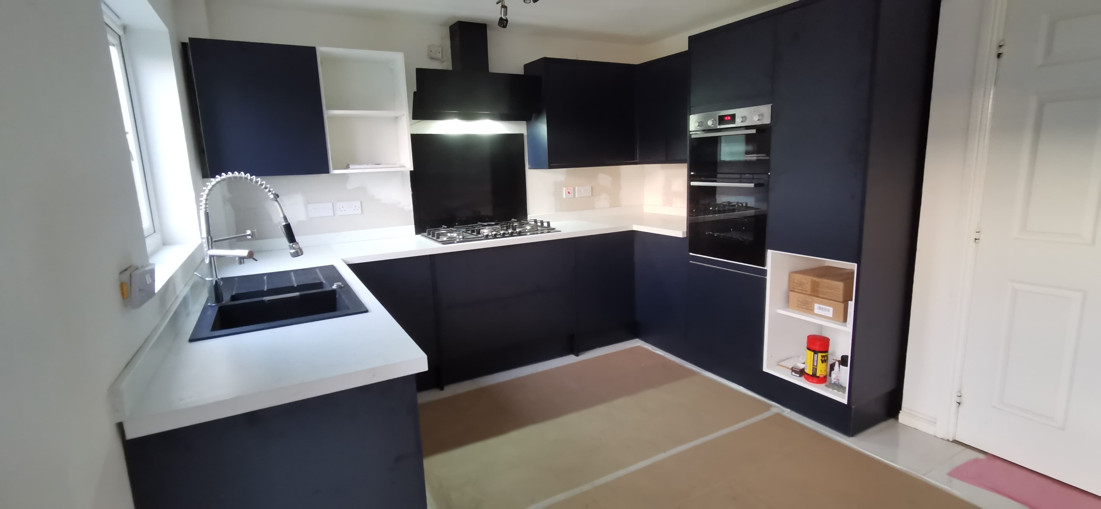 Fitted handleless kitchen with matte navy cabinetry and integrated appliances