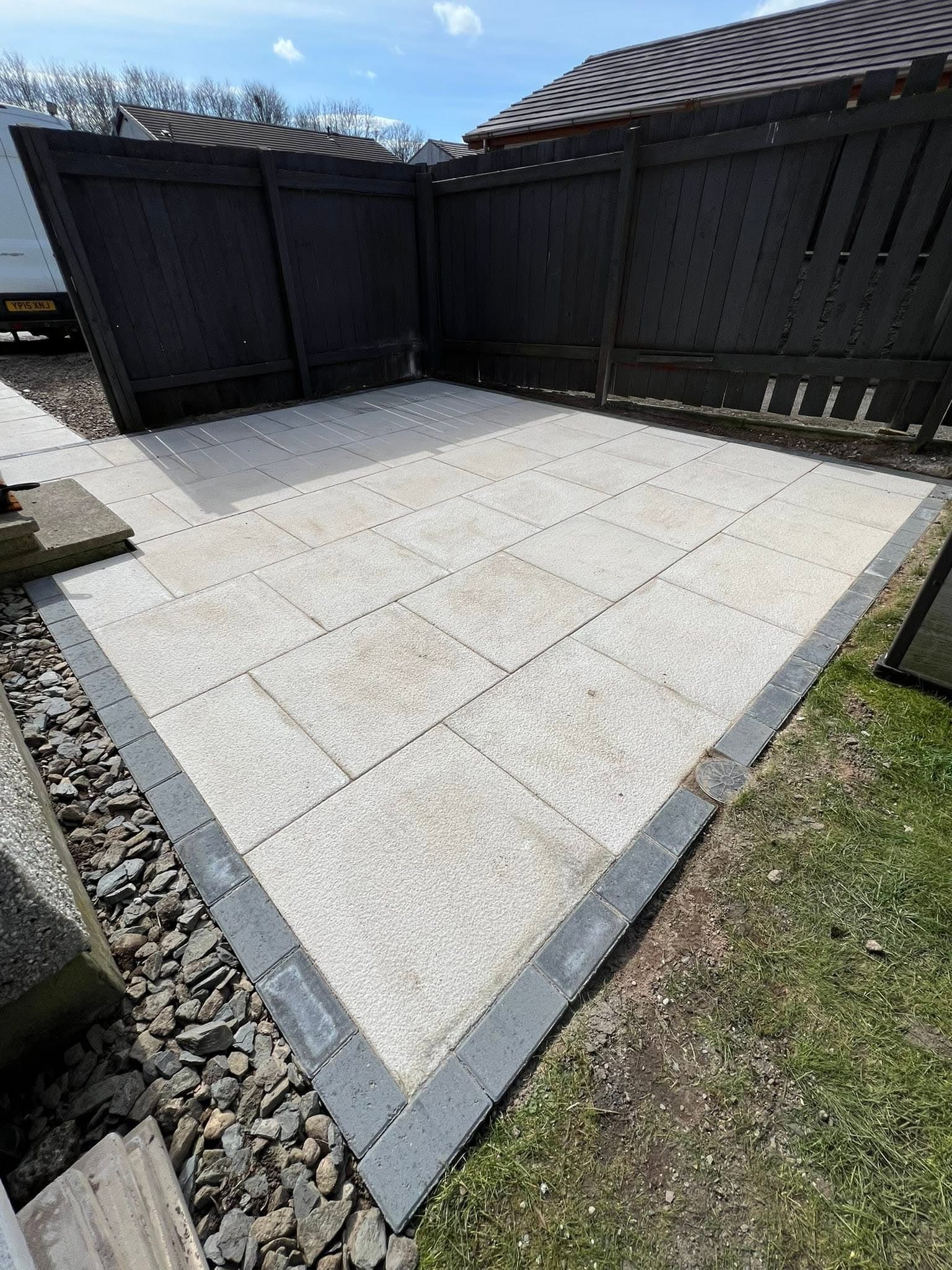 Landscaped side patio with grey porcelain slabs