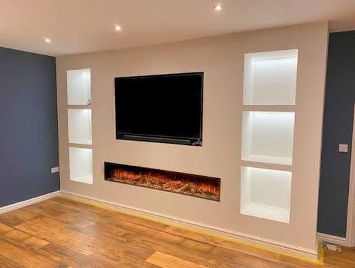 Fitted media wall with integrated electric fire and backlit alcove shelving